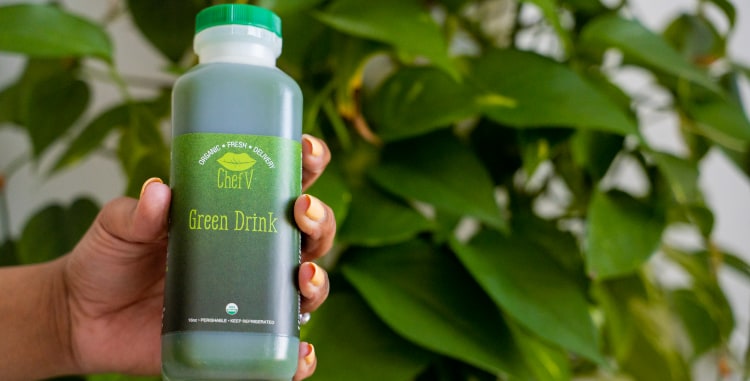 hand holding Chef V organic green drink bottle