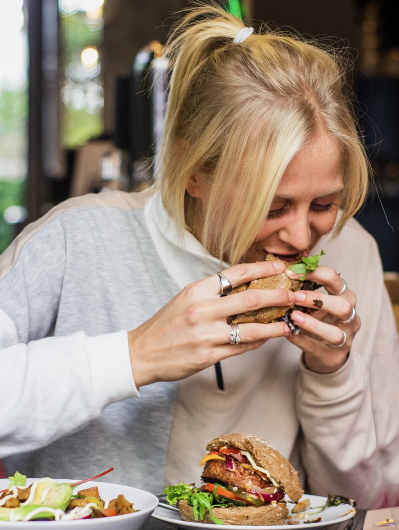 woman eating a plant based burger