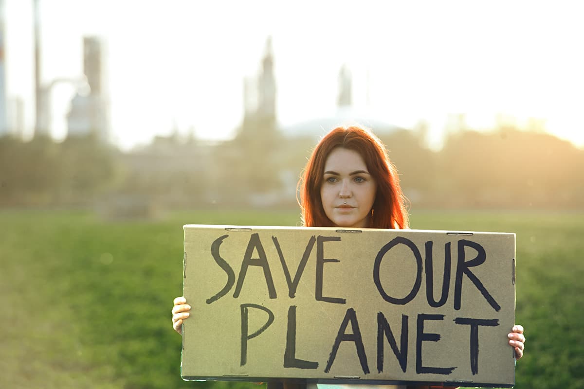 woman holding sign save our planet